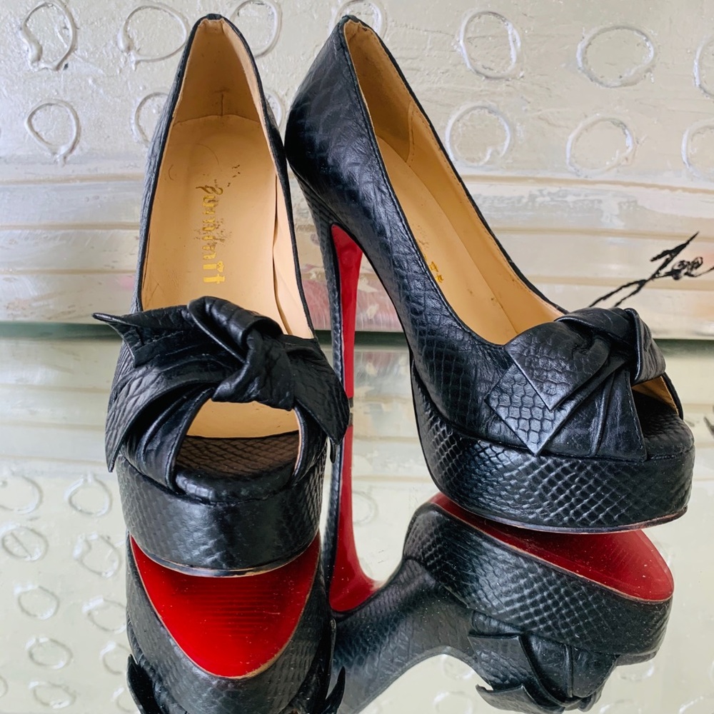 Black snakeskin pumps with red bottoms